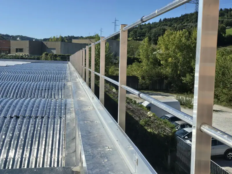 Camminamento di servizio con parapetto anticaduta sul bordo di una copertura curva